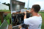 USGS employee performs maintenance on monitoring unit