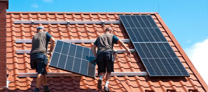 Workers Installing Solar Panels on Roof